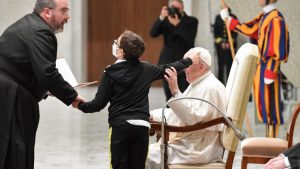 Bimbo pugliese va verso la poltrona del Papa durante l’udienza e lo saluta. Il Pontefice: libertà e spontaneità dei bambini siano una lezione